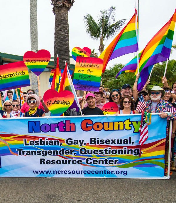 lgbtq banner and volunteers