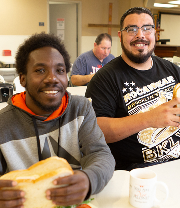 two men eating sandwiches
