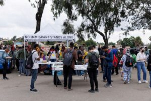 Migrant intake tent and group (ABC News)