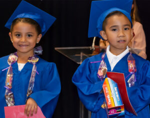 Two children wearing graduation robes