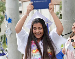 excited latina student graduate holding certificate of completion