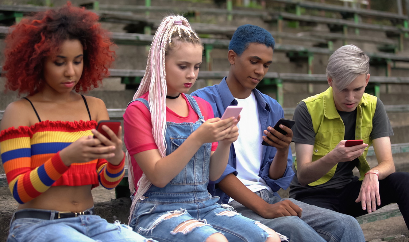 4 diverse youth on cell phones