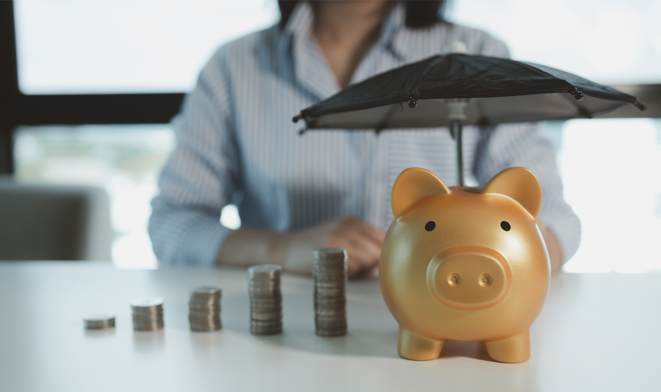 emergency aid_piggy bank with umbrella - rainy day fund concept
