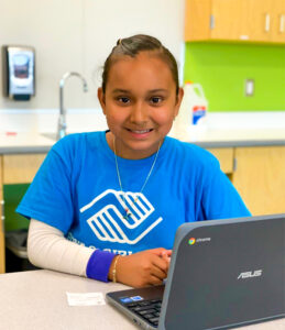 girl of color wearing blue logo'd tshirt of boys and girls club