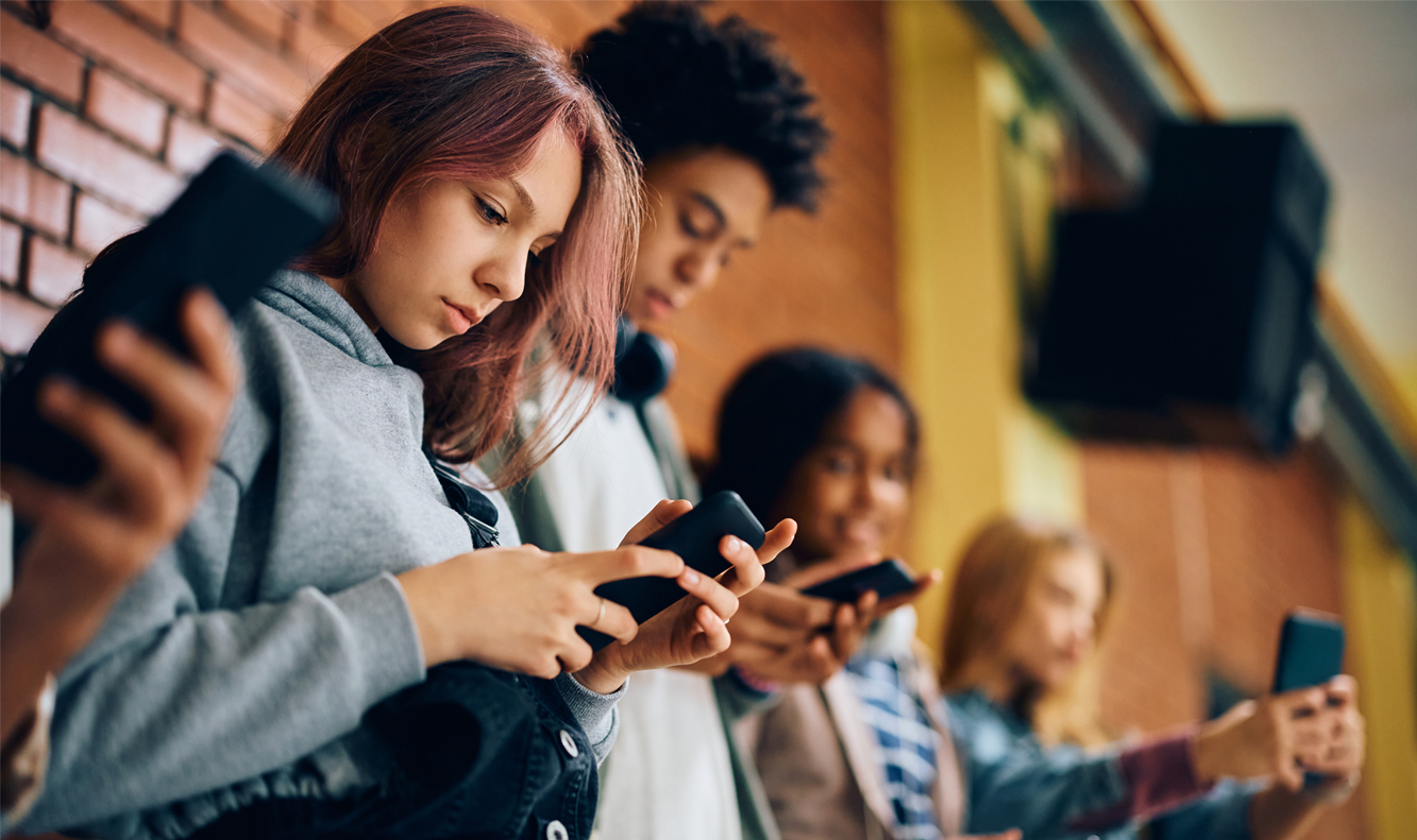 diverse teens on phone in hallway