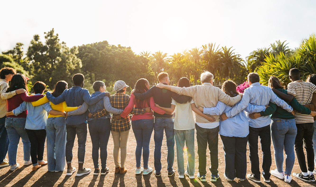 Row of diverse adults arm in arm outside_rear view perspective